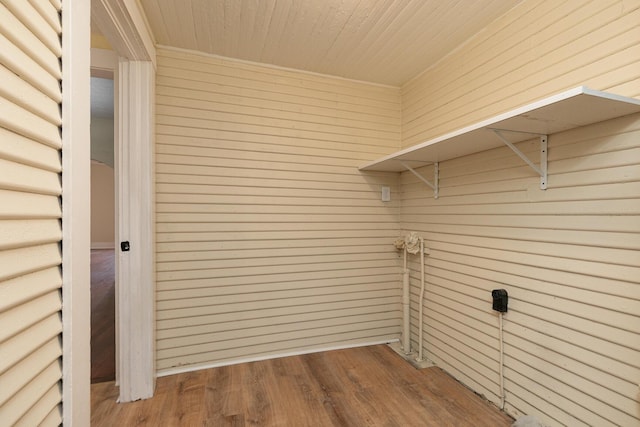 clothes washing area featuring wooden walls, wood ceiling, and hardwood / wood-style flooring