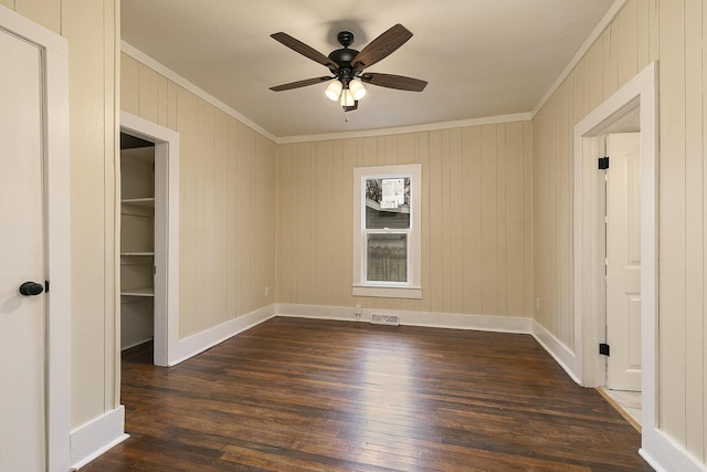 interior space featuring ornamental molding, ceiling fan, and dark wood-type flooring