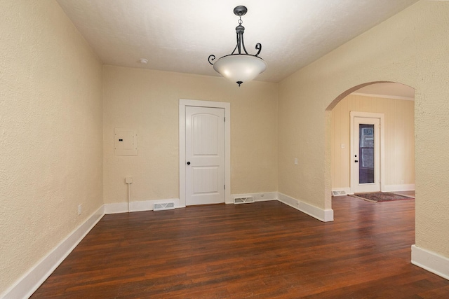 unfurnished room with electric panel and dark wood-type flooring