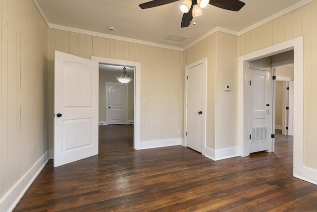 unfurnished room featuring dark hardwood / wood-style flooring, wooden walls, ceiling fan, and ornamental molding