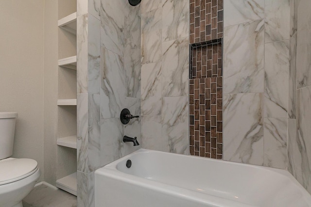 bathroom featuring built in shelves, toilet, and tiled shower / bath