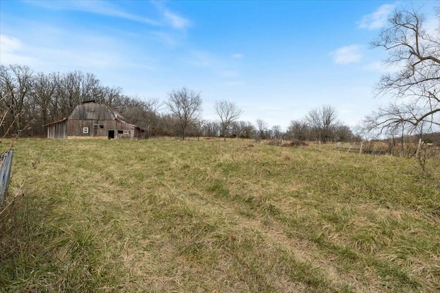 view of yard with a rural view and an outdoor structure