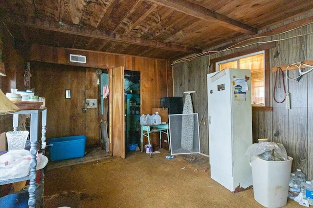 basement with carpet, white refrigerator, wooden ceiling, and wood walls