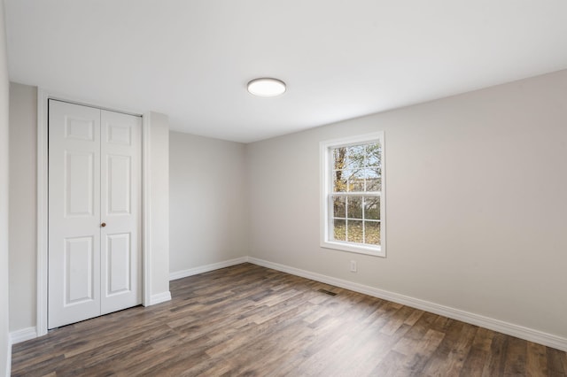 unfurnished bedroom featuring dark hardwood / wood-style floors and a closet