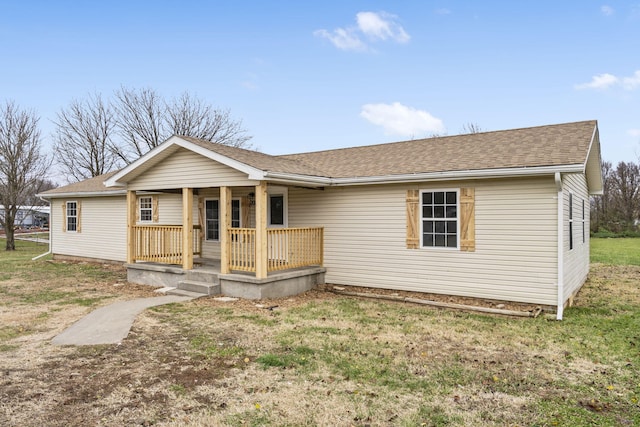 single story home featuring covered porch and a front yard