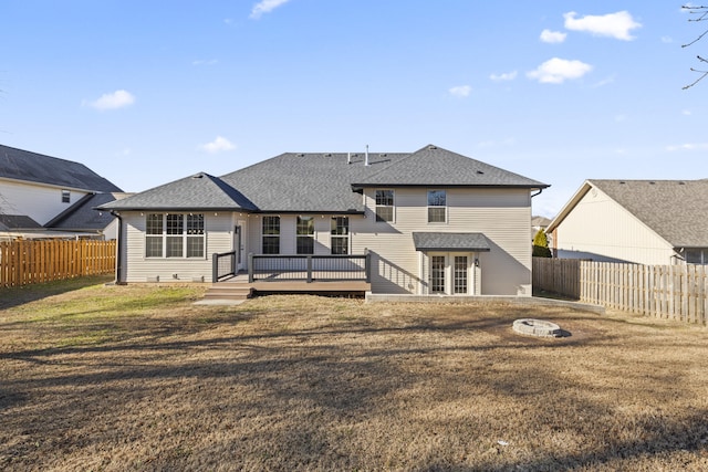 rear view of property featuring a yard and a deck