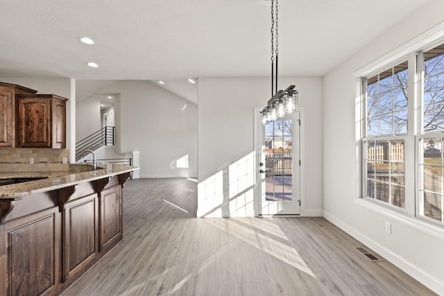 unfurnished dining area featuring light hardwood / wood-style floors, plenty of natural light, and sink