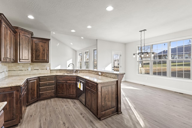 kitchen featuring kitchen peninsula, light stone countertops, dark brown cabinets, and light hardwood / wood-style flooring