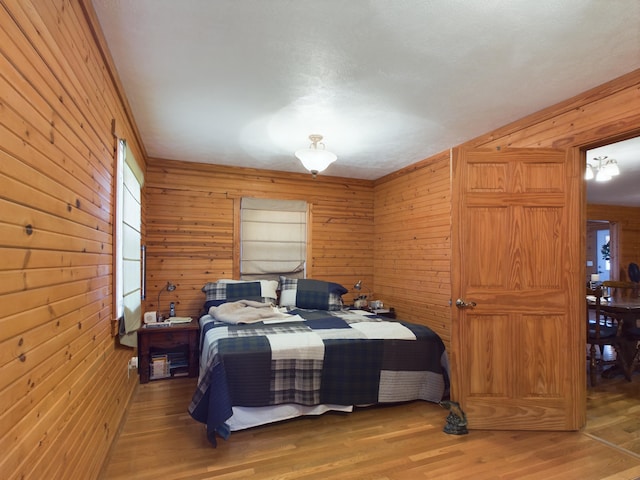 bedroom with wood walls and wood-type flooring