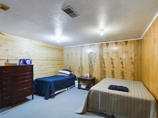 carpeted bedroom featuring a textured ceiling and wooden walls