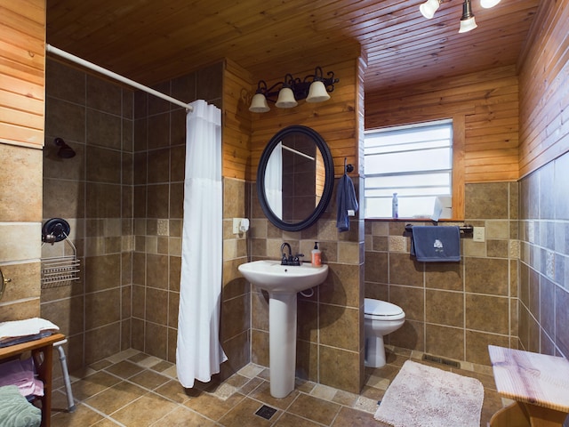 bathroom with wood walls, wooden ceiling, a shower with shower curtain, tile patterned flooring, and toilet