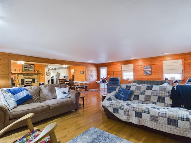 living room featuring wooden walls, plenty of natural light, and wood-type flooring