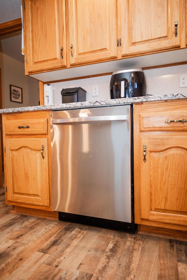 kitchen with dishwasher, light hardwood / wood-style floors, and a textured ceiling