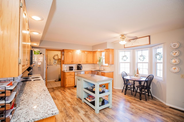 kitchen with light brown cabinetry, light wood-type flooring, a textured ceiling, ceiling fan, and white refrigerator