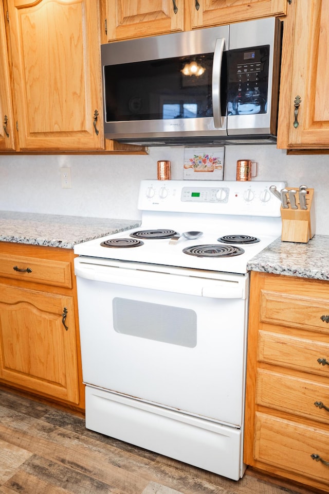 kitchen with light stone countertops, white electric range, and dark wood-type flooring