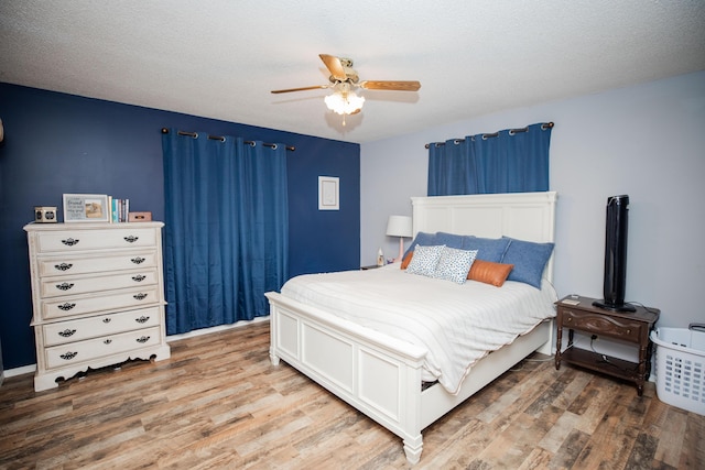 bedroom featuring wood-type flooring, a textured ceiling, and ceiling fan