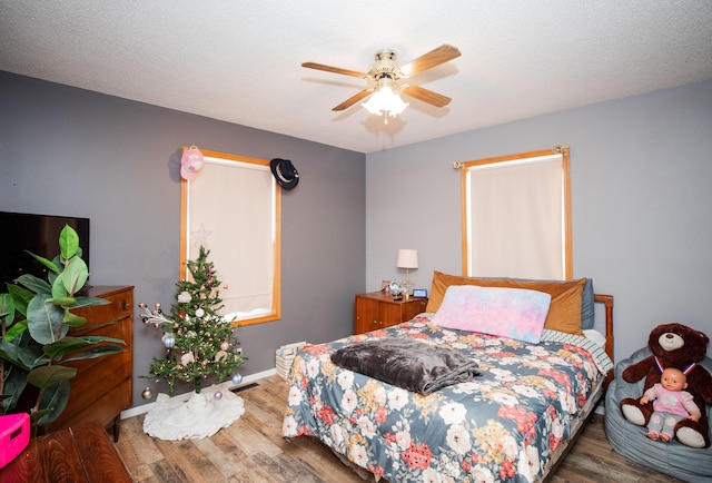 bedroom with a textured ceiling, dark hardwood / wood-style floors, and ceiling fan