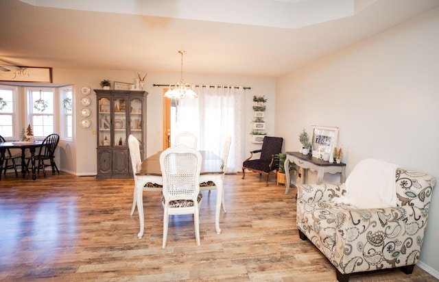 dining room with hardwood / wood-style floors and an inviting chandelier