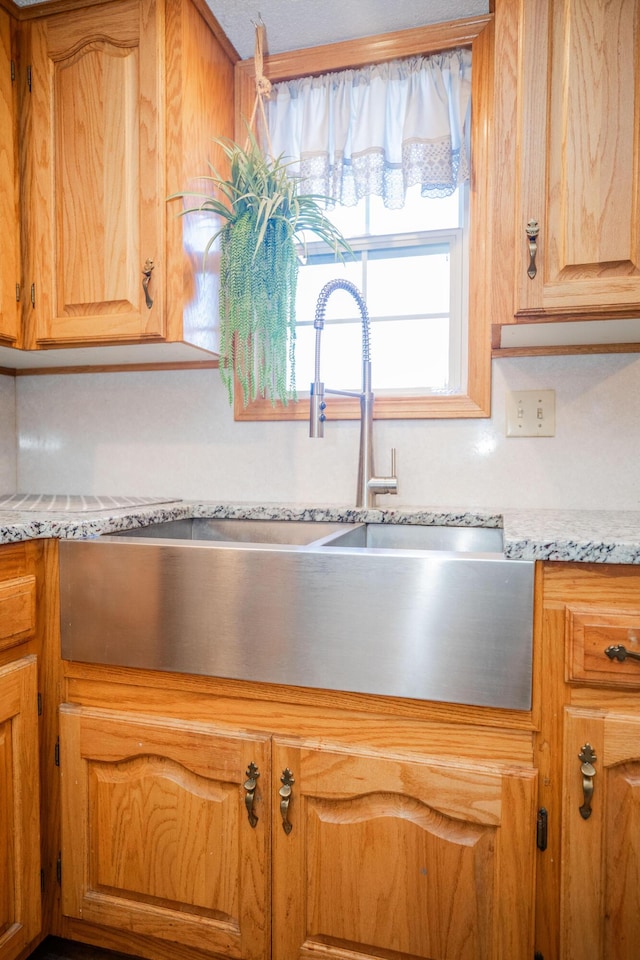 kitchen featuring light stone countertops and sink