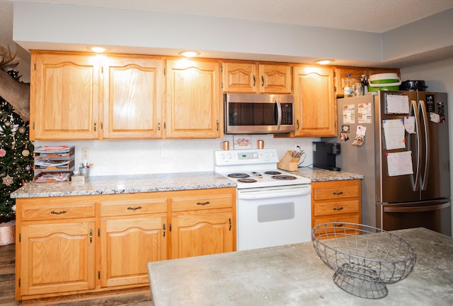 kitchen with a textured ceiling, stainless steel appliances, and light brown cabinetry