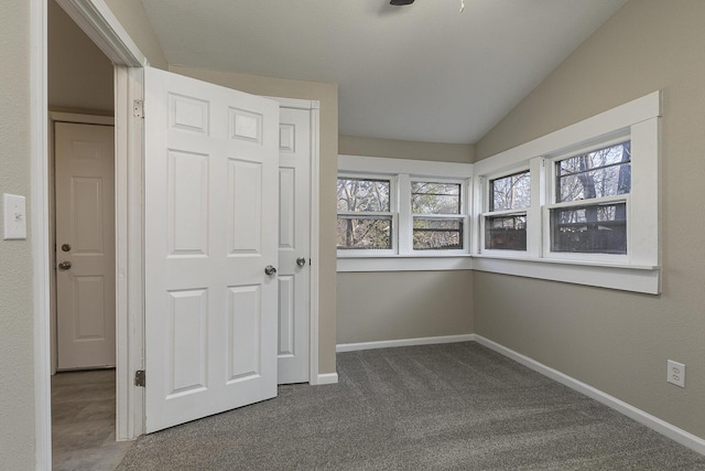 unfurnished bedroom with carpet floors, vaulted ceiling, and a closet