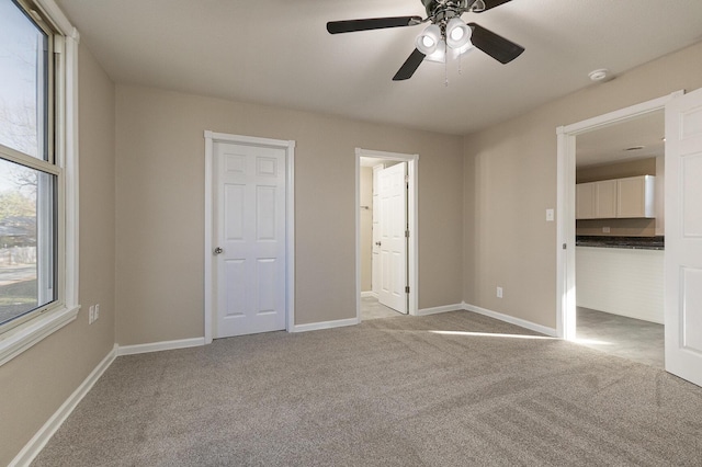 carpeted empty room featuring ceiling fan