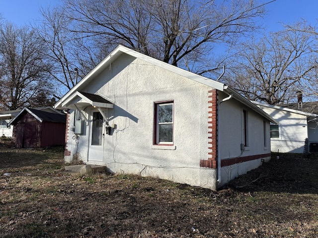 view of side of home with a storage shed