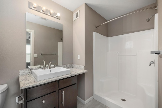 bathroom with vanity, toilet, and walk in shower