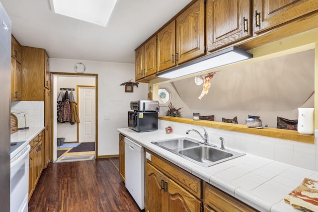 kitchen featuring tile counters, sink, dark hardwood / wood-style flooring, white appliances, and decorative backsplash