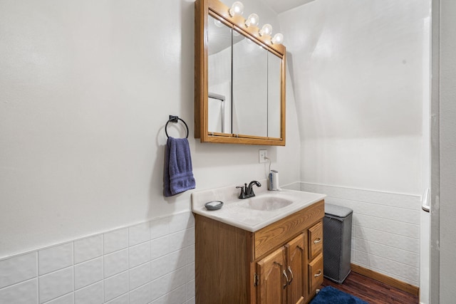 bathroom with wood-type flooring, vanity, and tile walls