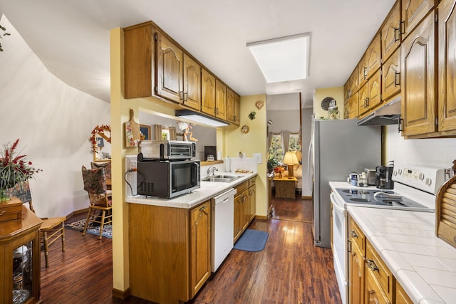 kitchen with tile countertops, white appliances, dark hardwood / wood-style floors, and sink