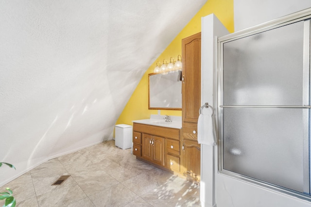 bathroom with shower / bath combination with glass door, vanity, and vaulted ceiling