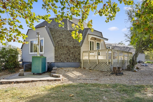 rear view of property featuring a deck