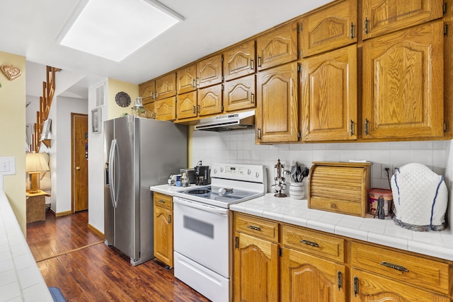 kitchen featuring white range with electric cooktop, decorative backsplash, tile counters, and dark hardwood / wood-style floors