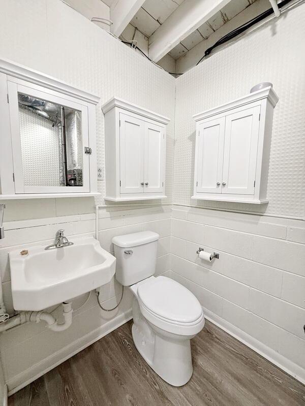 bathroom featuring beamed ceiling, hardwood / wood-style flooring, toilet, and sink