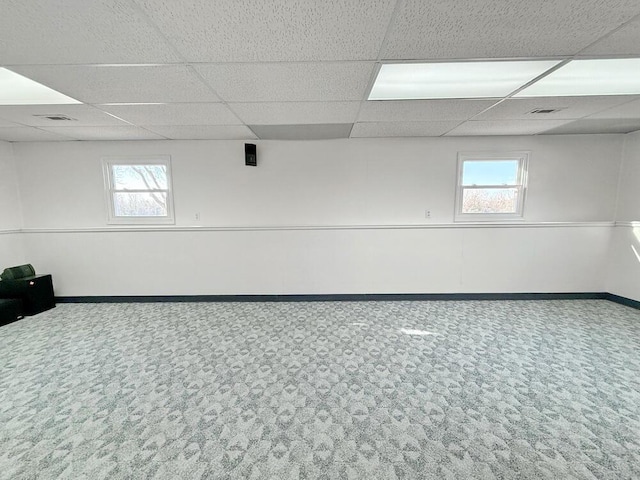 basement featuring carpet and a paneled ceiling