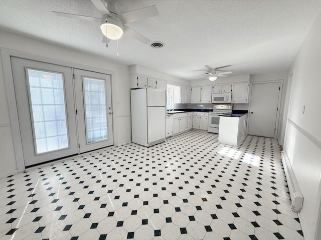 kitchen featuring white cabinetry, ceiling fan, a baseboard radiator, and white appliances