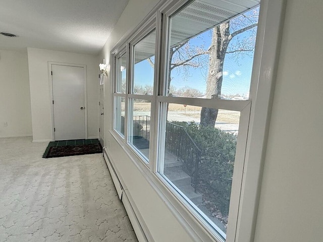 doorway to outside with light colored carpet and a textured ceiling