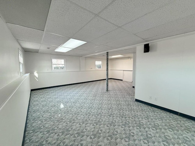 basement with carpet flooring and a paneled ceiling