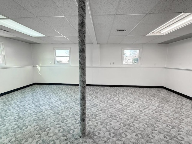 basement with carpet, a drop ceiling, and a wealth of natural light