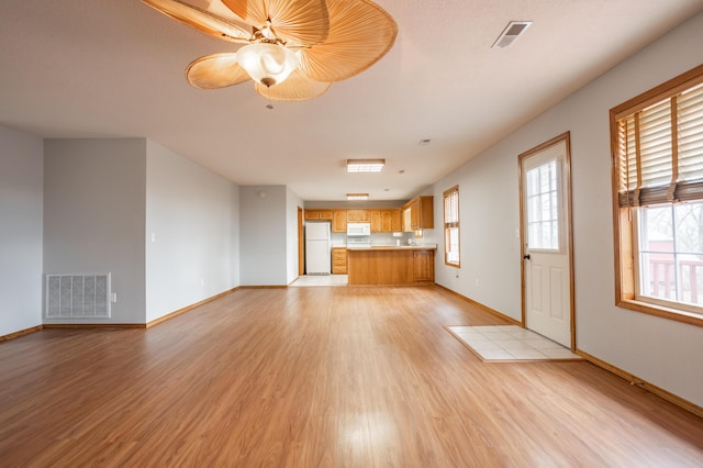 unfurnished living room with ceiling fan and light wood-type flooring