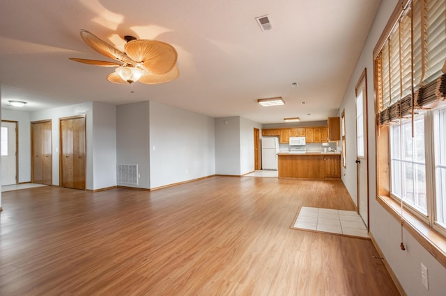 unfurnished living room featuring light hardwood / wood-style flooring and ceiling fan