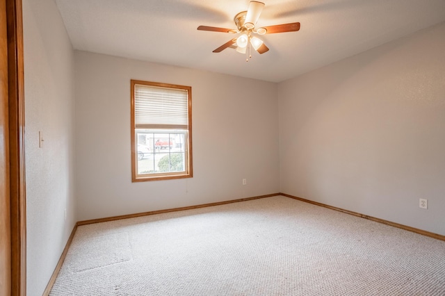 carpeted spare room featuring ceiling fan