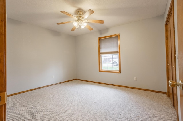 carpeted spare room with ceiling fan