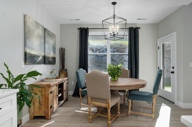 dining area featuring plenty of natural light, a chandelier, and light hardwood / wood-style flooring