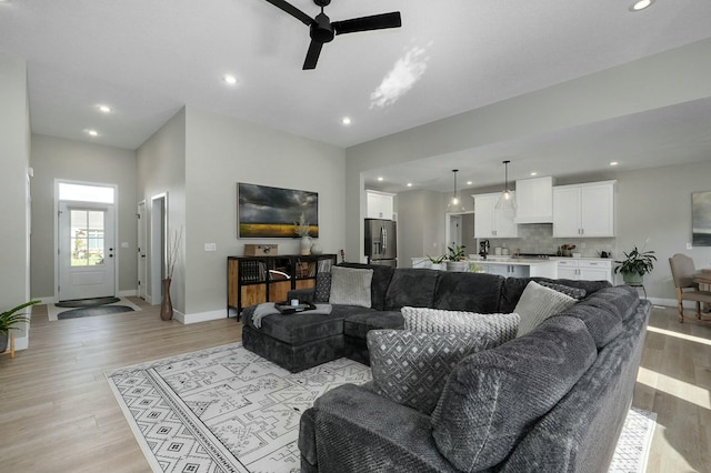 living room featuring light hardwood / wood-style flooring and ceiling fan