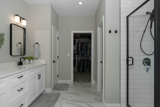 bathroom featuring a shower with door and vanity