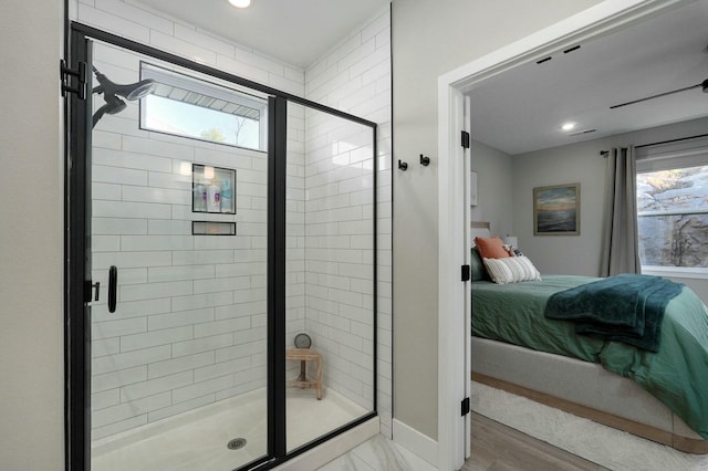 bathroom featuring wood-type flooring, a shower with shower door, and a healthy amount of sunlight