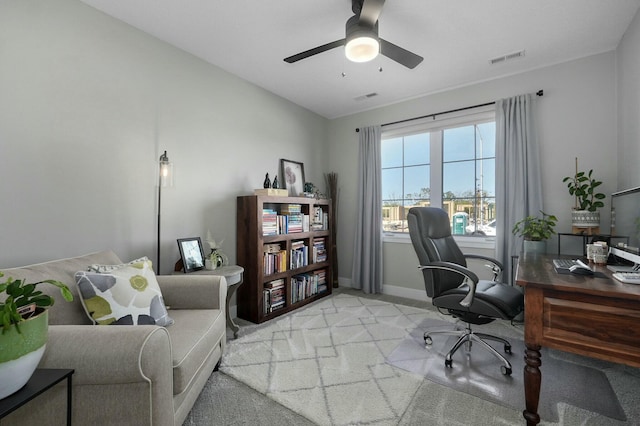 carpeted office space featuring ceiling fan