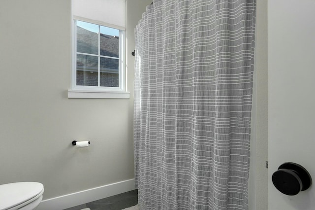 bathroom featuring a shower with shower curtain and toilet